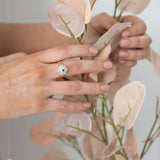Natural Green Emerald and Diamond Ring Set in Yellow gold Floral Shape on hand holding  peach leaves plant