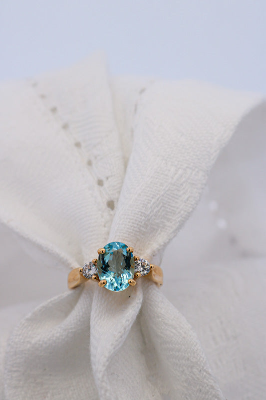 Blue Aquamarine and Diamond Ring Set in yellow gold on white background