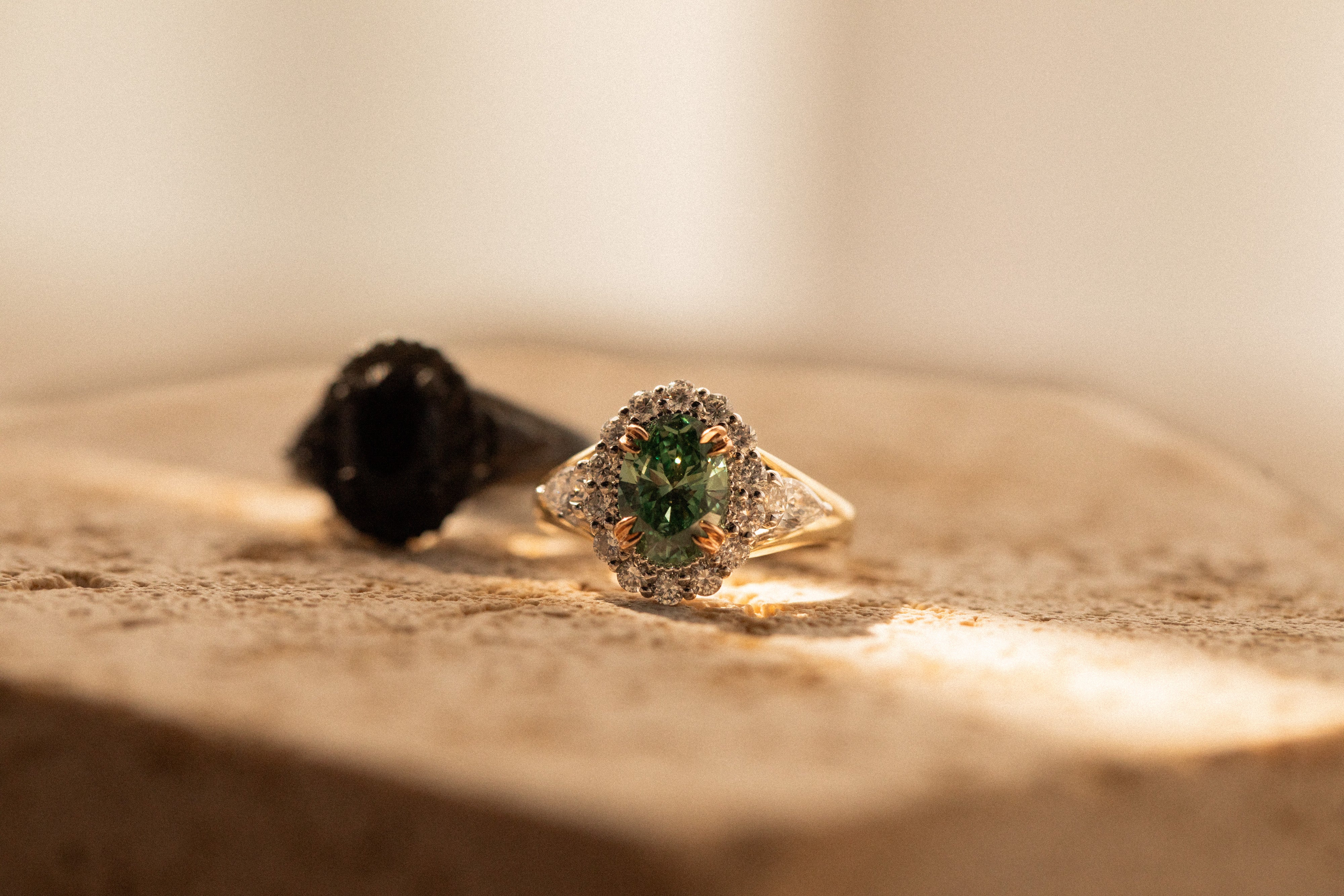 Gold ring with a green gemstone on a wooden surface