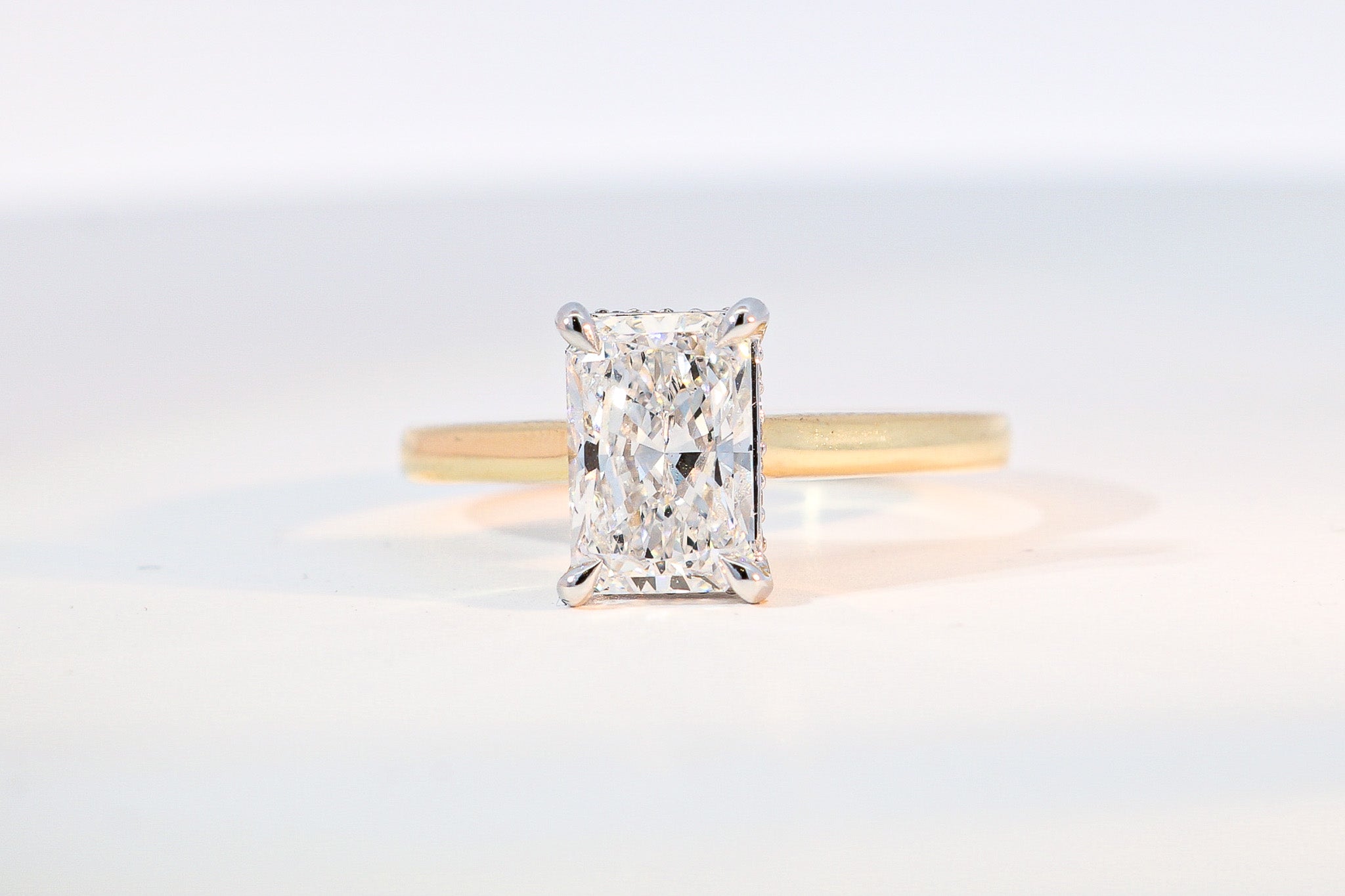 hidden halo radiant cut engagement ring yellow gold band