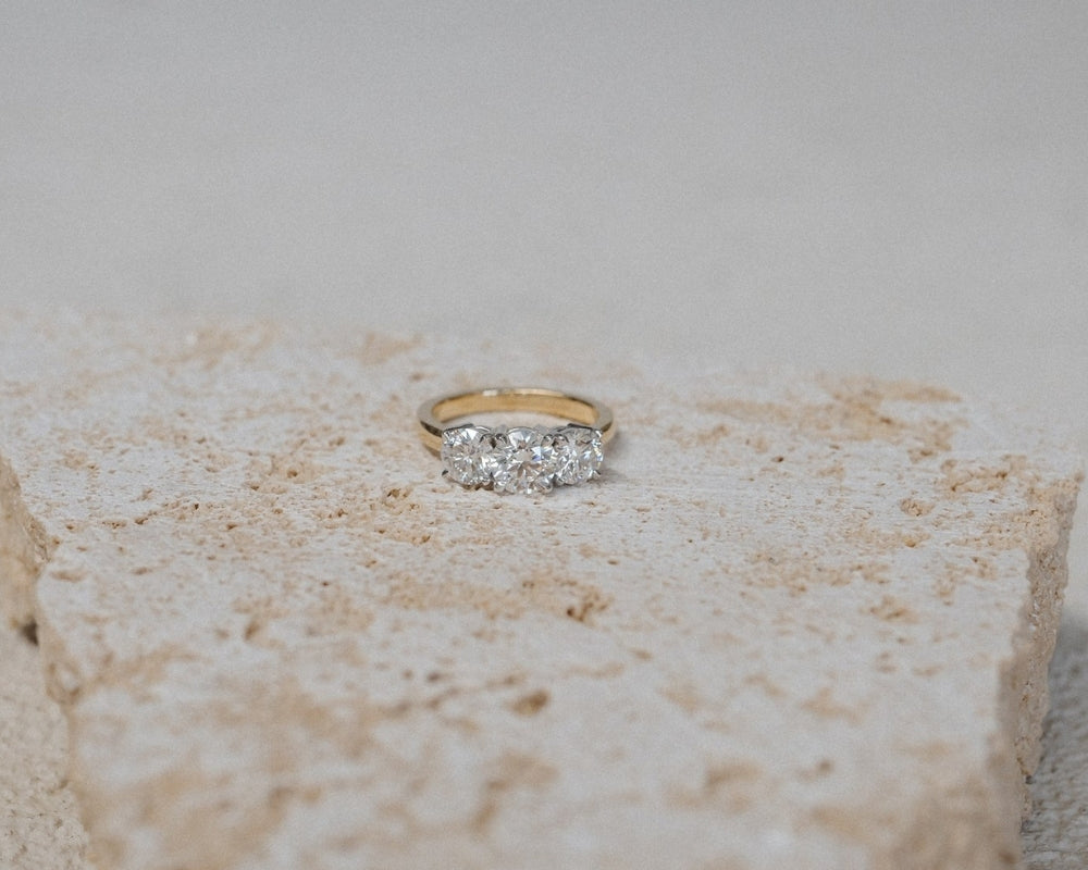 Gold ring with diamonds on a textured stone surface